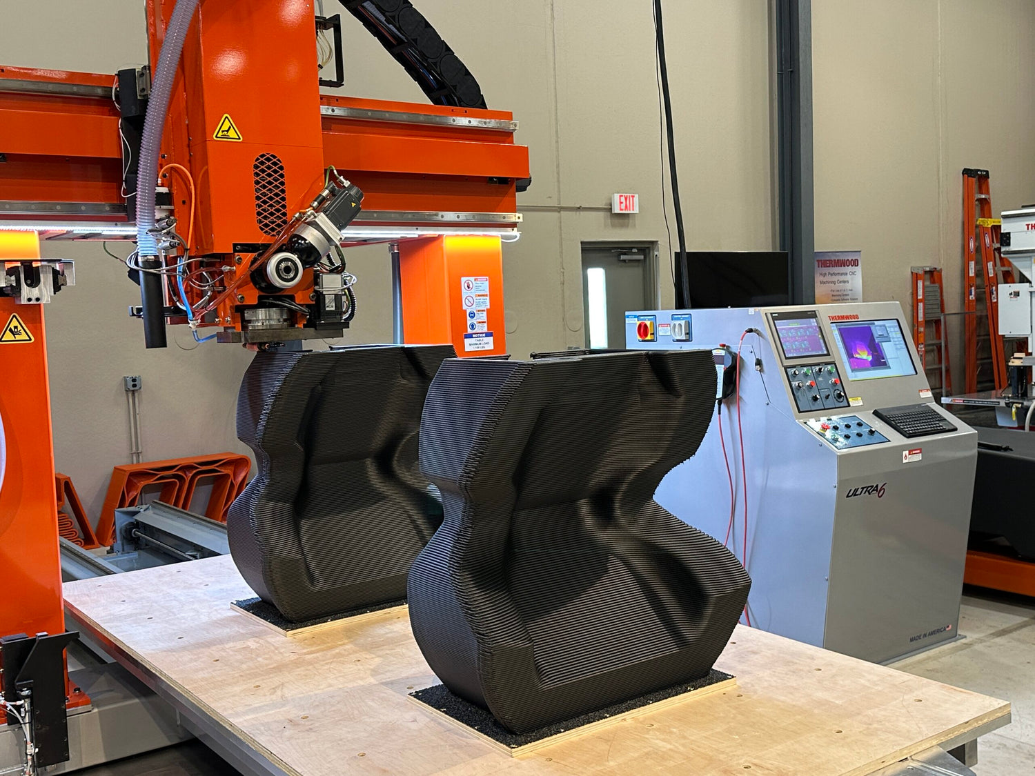 3D printing machine in operation with a partially completed object on a table.