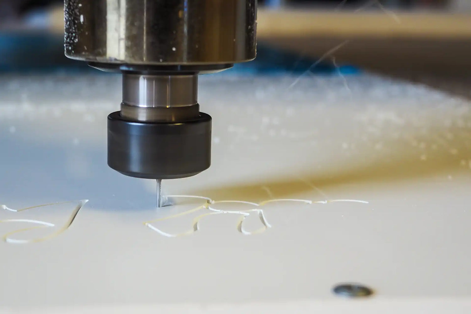 CNC machine cutting a piece of material with a close-up view of the tool and workpiece.