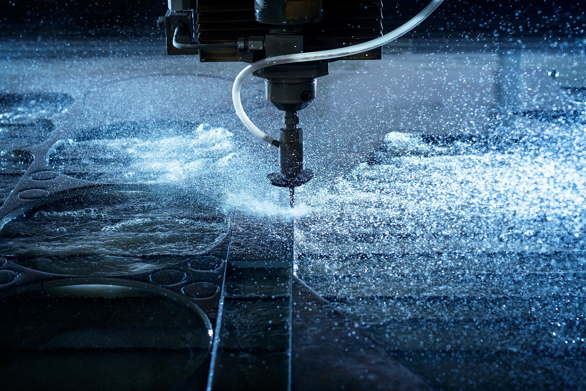 Water jet cutting metal in a factory setting