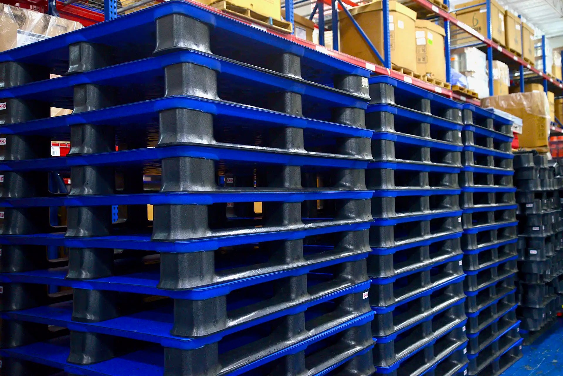 Stack of blue plastic pallets in a warehouse setting