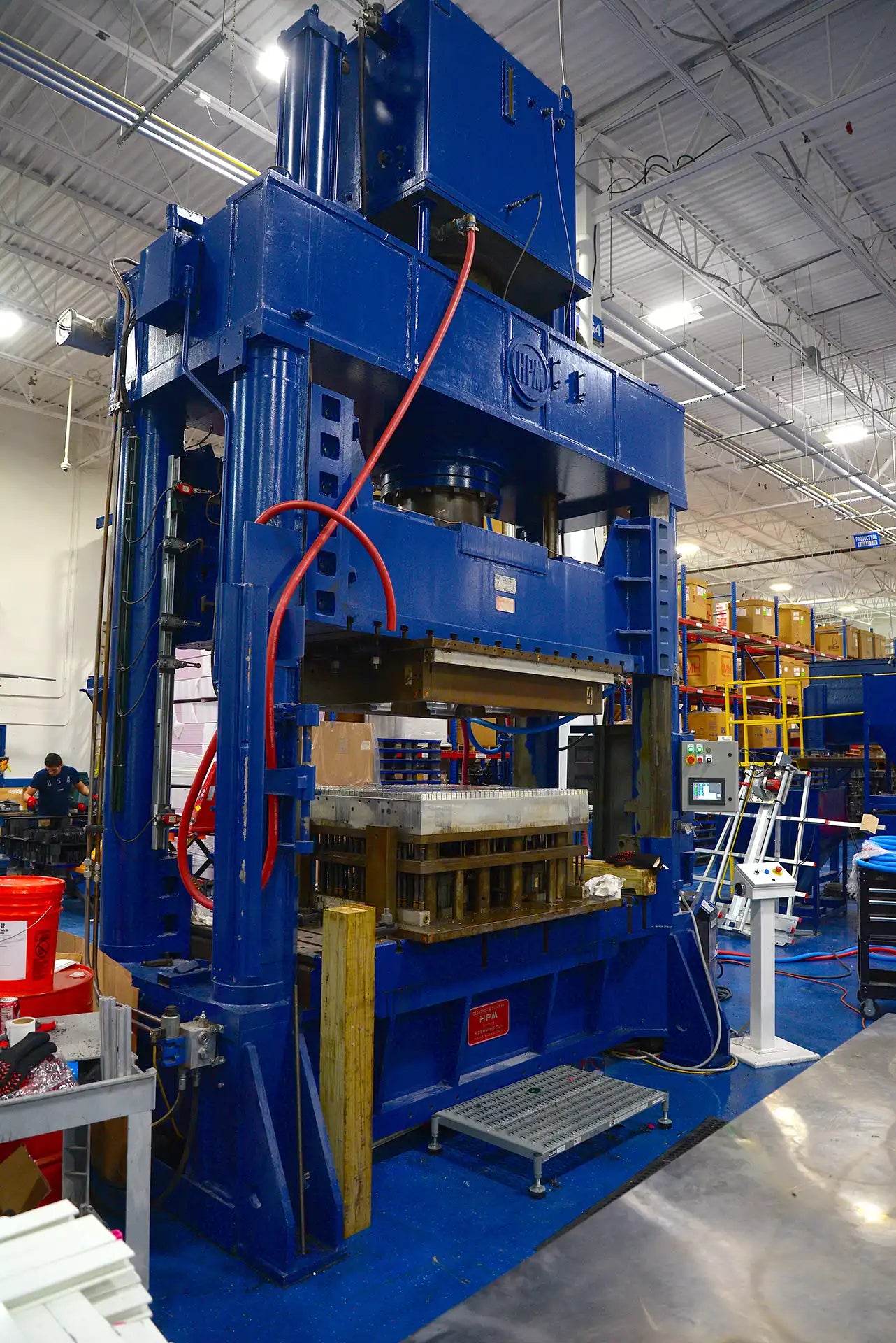 Large compression molding machine in a warehouse setting
